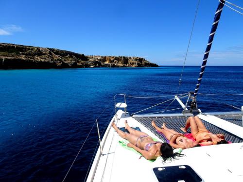 Ragazze prendono il sole a bordo di un catamarano durante escursione nell'Arcipelago di La Maddalena