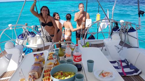 Escursionisti durante pranzo in barca a vela nel nord della Sardegna